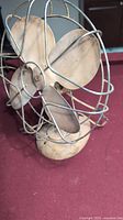 Front angle close-up of vintage steel table fan showing three blades and cage with worn original paint.