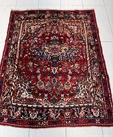 Full view of the Persian Hamadan rug showing overall pattern, color and size on light flooring.
