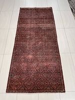 Full view of the rectangular Persian rug showing overall pattern and size on tiled floor.