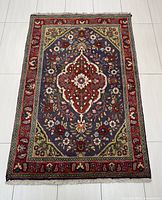 Full view of the rectangular Tabriz rug showing overall design and color scheme, laid flat on light flooring.