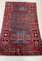 Full view of the Zanjan hand knotted Persian rug showing overall geometric pattern and color scheme in red, blue, black tones.