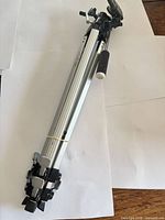 Tripod folded showing aluminum legs, flip locks, grip handle