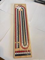 Full view of sealed wooden cribbage board showing 3-track layout and Bicycle branding
