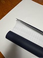 roll of black matte vinyl partially unrolled showing grid backing