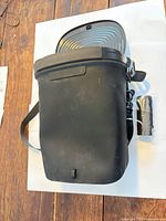 Full exterior view of black car trash can showing strap and overall condition