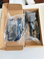 Open box showing two sealed Commountain speaker microphones