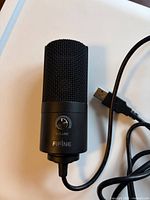 Front view of FIFINE microphone showing grille, volume knob and USB-A plug