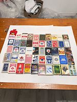 All 50 decks laid out in rows showing variety of brands and designs