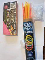 Tube of glow stick bracelets, fluorescent envelope pack, connectors bag
