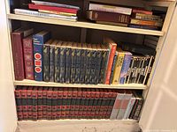 Full bookcase showing Funk & Wagnalls set bottom shelf, Childcraft set middle shelf, reference singles