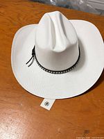 Top view of white cowboy hat showing leather hatband and tag