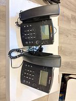 Two Polycom RingCentral VoIP desk phones with handsets, cords and stands