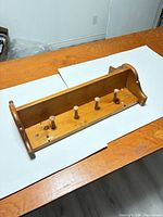 Angled overview showing entire wood coat rack shelf on table