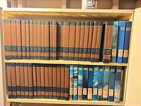 Two shelves showing full encyclopedia run and assorted year books