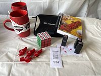 Full set including mugs, tube holder, notebook, Rubik's cube, stamps, and whistles arranged on white backdrop.