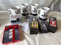 Full lot showing four hockey puck mugs, mini Zamboni, five mini hockey sticks in boxes, coasters in branded boxes, and Christmas cards.