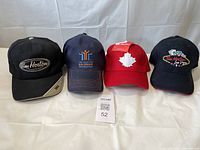 Front view of four Tim Hortons baseball hats showing logos and colors