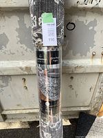 Photo of rolled-up rug with Centenno Collection label showing brand and rug type