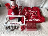Full lot showing XL t-shirt, baseball cap, umbrella, keychains, whistles, license plate holders, plastic cups, and timbit puzzle