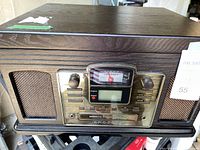 Front view showing woodgrain case, speaker grilles, and brass-tone control panel with Crosley branding