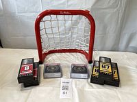 Full lot arrangement showing red Tim Hortons branded hockey net with 8 Ottawa Senators coasters and 5 mini hockey sticks in packaging.