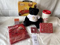 Photo showing entire lot: Timbits apron in red packaging, mini Rubik's Cube with Tim Hortons logo, Camp Day teddy bear in white t-shirt, SuperTim plastic cup, 200 piece puzzle, Tim Hortons lunch box, playing cards and sugar tin.