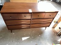 Front view showing full six drawer dresser, tapered legs, brass knobs