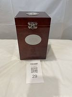 Full frontal view of the rectangular wooden humidor with glossy reddish-brown finish and metal Tim Hortons logo plaque on the front, closed with a metal clasp lock.