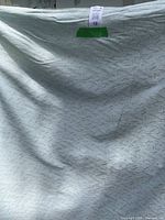 Light blue fabric roll with subtle textured pattern, shown flat with folds.