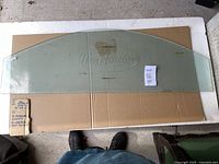 Large Tim Hortons frosted glass panel with etched logo, placed on cardboard with visible sticker residue and smudges.