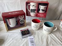 Full lot overview showing four Tim Hortons mugs, two boxed with bear design and vertical red stripe mug, two unboxed with grey logo and colored interiors, Keurig coffee pods and Senator puck coasters.
