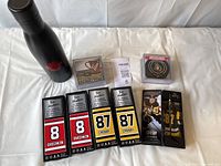 Photo showing the black Tims Hortons water bottle, five mini collectible hockey sticks in original boxes (3 Crosby, 2 Ovechkin), and a set of eight hockey puck coasters in packaging.
