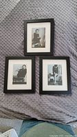 Three framed and matted black and white 1940s photographs of a woman posing, arranged on a textured gray fabric surface.