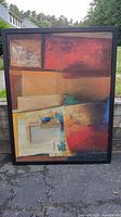 Full front view of large abstract painting showing the color blocks and black wooden frame with slight paint wear.