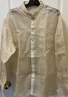 Front view of men's Barong Tagalog showing the embroidered design and button front on light sheer fabric.