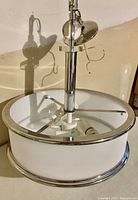 Ceiling light fixture chandelier showing overall structure with chrome support and white shade