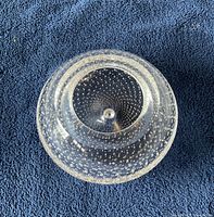 Top view of a clear crystal display bowl showing a raised central base and embedded bubble design throughout the glass.