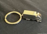 Close-up of truck-shaped key ring showing polished metal surface and detail.