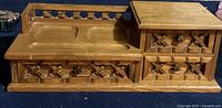 Front view of the wooden jewellery box with lattice carved details, showing the drawers and recessed surface compartments.