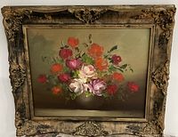 Front view of a vintage framed oil painting showing a colorful floral bouquet in an ornate frame with wear and patina.