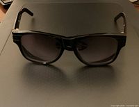 Front view of black Burberry prescription sunglasses with dark tinted rectangular lenses.