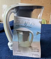 Close image of the Clear2O water filtration pitcher with the manual in front showing the model numbers and branding.