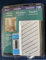 Front view of unopened Carlol RC3250 wireless plug-in chime unit with push button transmitter in original clear plastic blister pack with product details on card insert.