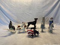 Overview of all figurines in the lot including animal and children figurines.