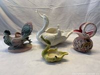 All four ceramic pieces grouped together: two swan planters, a rooster planter, and honey jug
