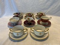 Group photo showing 8 teacup and saucer sets arranged in two rows on a plain backdrop