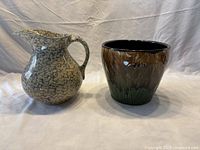 Two pottery items, a spongeware pitcher and a jardiniere planter, shown side-by-side on a white cloth backdrop.