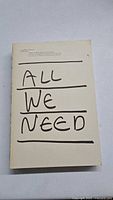 Front cover of the book named All We Need with handwritten text and minimalist design.