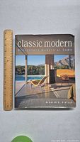 Front cover of 'Classic Modern: Midcentury Modern at Home' book with midcentury modern living room photograph on cover and ruler for scale.