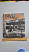 Front cover of the book showing the title 'BAWA' in large orange letters and a black and white photo of architectural space.